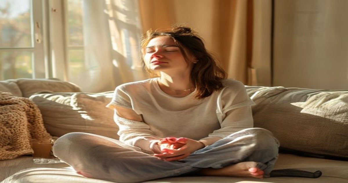 Person practicing breathing exercise on couch during anxiety attack relief